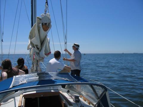 Unfurling the sails on a group sailing trip.
